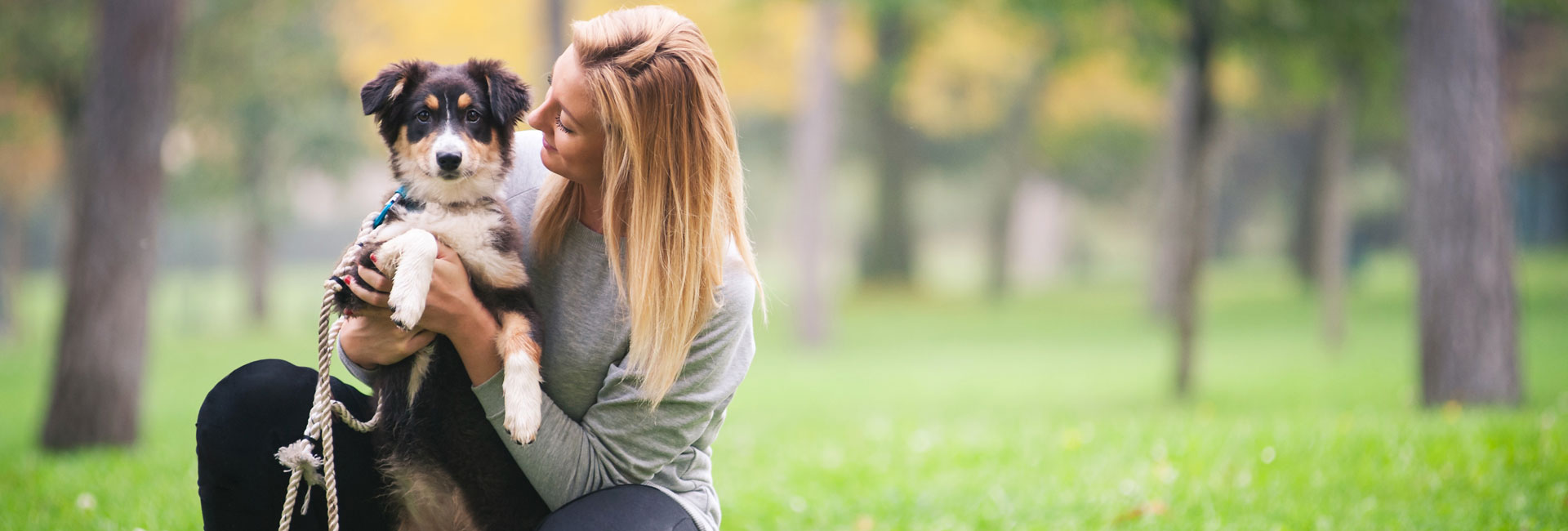 Young Woman Playing with Australian Shepherd Dog